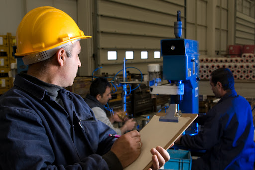 Funcionários de uma empresa aplicando as dicas de como organizar a produção industrial a fim de conseguir resultados promissores.