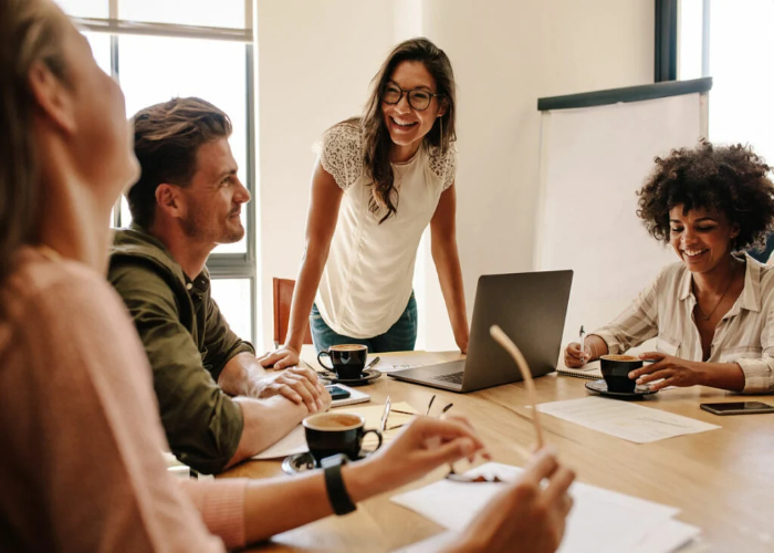 Colaboradores de uma empresa adotando uma das melhores boas práticas do trabalho em equipe: a comunicação assertiva.