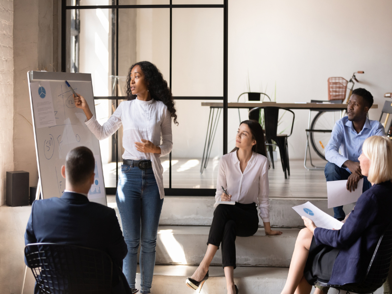 Colaboradores interagindo durante treinamento corporativo presencial nas instalações da empresa.