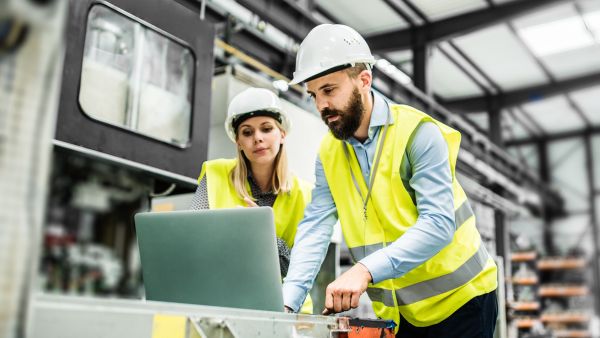 Gestores avaliando processos produtivos em erp com notebook