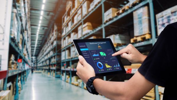 Profissional checando diferentes informações da cadeia de suprimentos no tablet em sistema web