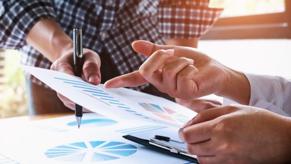 Colaboradores comparando dados financeiros da empresa com metas estratégicas