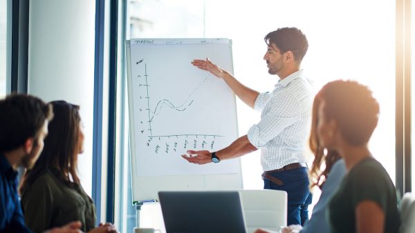 Gestor explicando as equipes importância e fases de implementação do ERP para e-commerce na industria