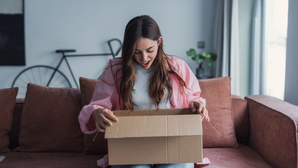 Client feliz fazendo unboxing de produto após recebê-lo apenas 1 dia depois de comprá-lo