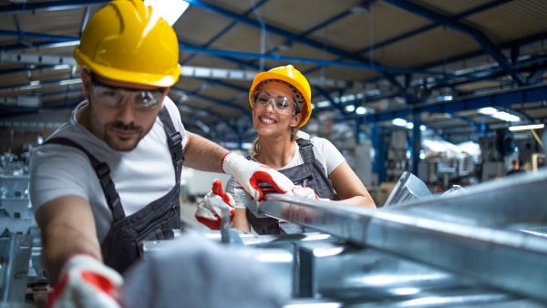 Colaboradores trabalhando satisfeitos em indústria com equipamentos e processos eficientes