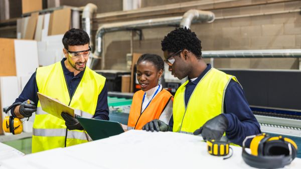 Colaboradores e líder de produção analisando o plano mestre de produção