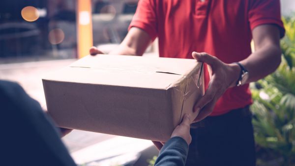 Entregador dando o produto nas mãos do cliente