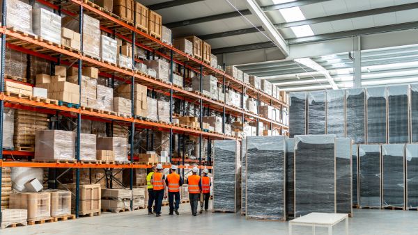 Profissionais conversando no armazém sobre giro de estoque de produtos da indústria